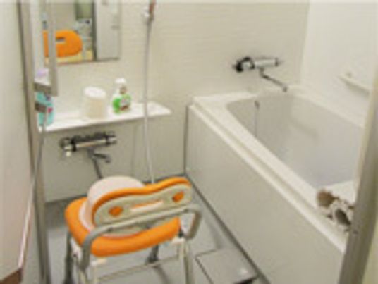 施設の写真 洗い場には椅子が置いてあるので、足腰に不安がある入居者様でも安心できる。浴槽には手すりが完備されている。