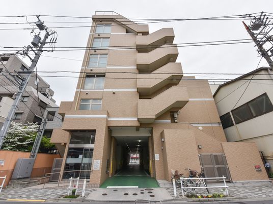 ベージュ色の建物エントランス
