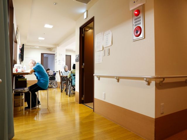 廊下から見た食堂 廊下 明るい廊下と続く食堂では、利用者様がゆったりと食事を楽しんでおり、支援をしているスタッフの姿も見受けられます。