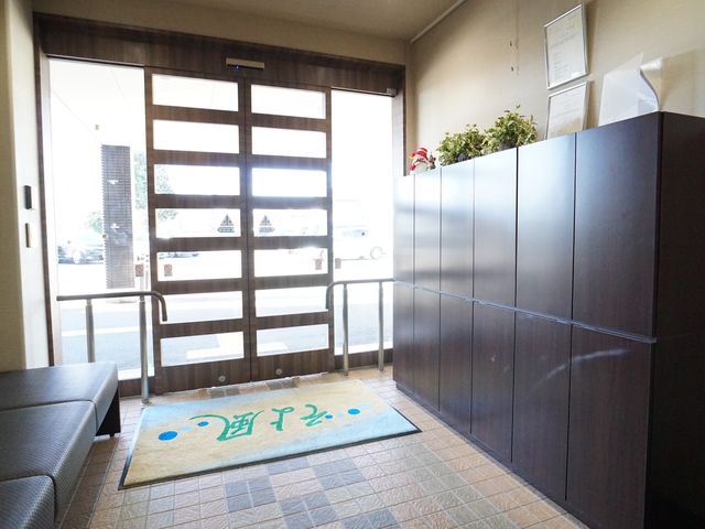 明るいエントランス風景 玄関 ゆったりとした受付エリアです。清潔感のある室内と誘導しやすい明るい出入り口が特徴です。