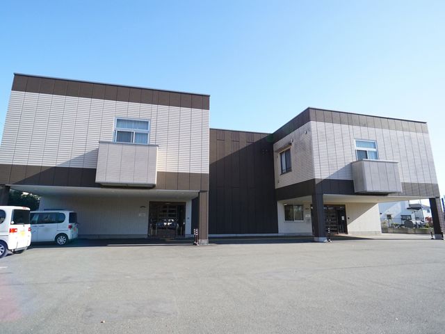 現代的な建物の外観 外観 落ち着いた色合いの外壁が特徴的な建物です。手前に駐車スペースがあり、来訪者の利便性が考えられています。
