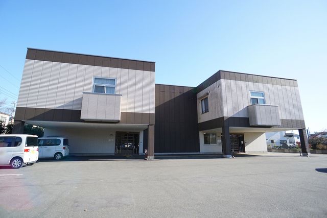 現代的な建物の外観 外観 落ち着いた色合いの外壁が特徴的な建物です。手前に駐車スペースがあり、来訪者の利便性が考えられています。