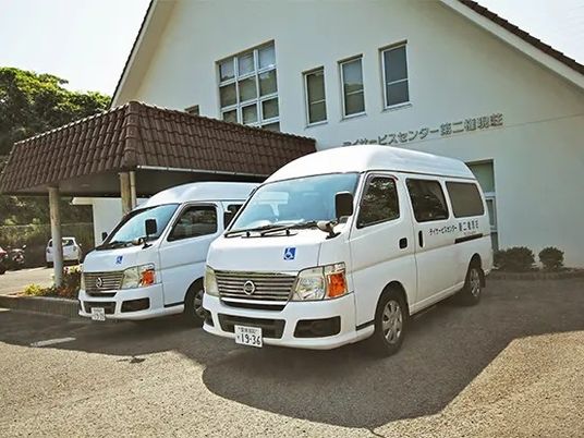 送迎車が並ぶ施設外観  