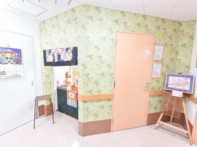 彩り豊かな通路の一角 受付も季節毎に飾り付け 花柄の壁紙が特徴の通路は、訪れる人々へ暖かい印象を与えるデザインです。椅子が置かれ、一息つくこともできます。