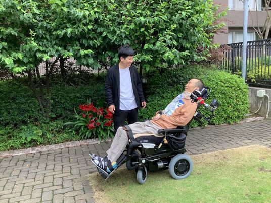 車椅子の方とスタッフ庭