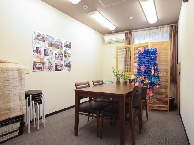 居室のテーブルと椅子 面会室 落ち着いた雰囲気のある部屋には、活気のある花と手作りの装飾があります。