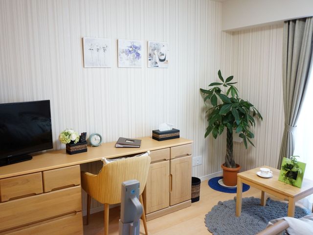 快適な居室の様子 居室 木目調の家具が温もりを感じさせる居室です。大型テレビや快適なチェアで、くつろぎの時間をお過ごしいただける空間となっています。