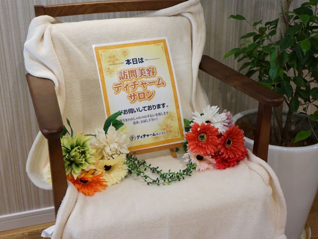 花飾り付き掲示物 共有スペース 暖かみのある色調でデザインされた掲示物が、来訪者を温かく迎えています。心地よい環境づくりに配慮されている様子が伺えます。