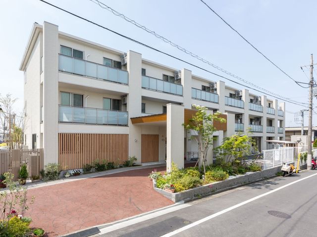 モダンな建物の外観 外観 一階に柔らかな木目をあしらったエントランスを持つ、清潔感のあふれるモダンな建築です。ゆったりとした空間設計が、働きやすい環境を提供します。