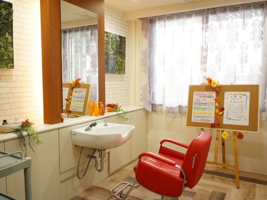 理美容室は広々としており、赤い椅子やコルクボードなど、本格的な内装となっている。壁やカウンターには、造花などで飾りつけもされている。