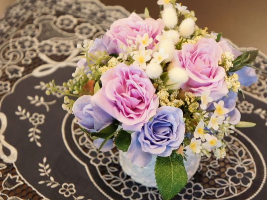 相談室に並べられているテーブルの隅には、紺色のクロスの上にピンク色や青色の造花が綺麗に飾られている。
