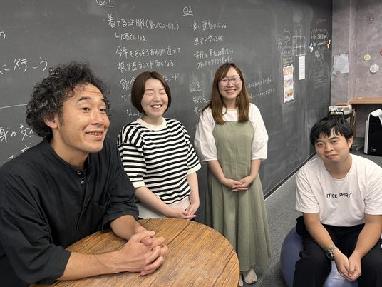 笑顔のスタッフが並ぶ会議室  