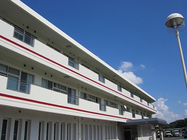 青空の下の建物外観 外観 広々とした施設の建物は、青空の下で自然に囲まれています。快適な就業環境を提供します。