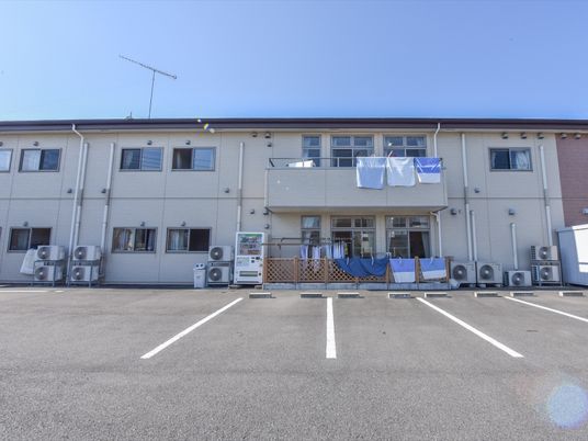 白い壁の建物と駐車スペース