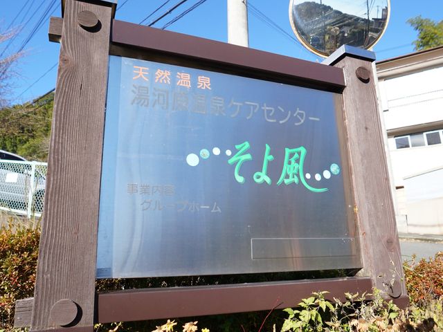 案内看板のクローズアップ ロゴ 暖かい色合いの案内看板が、訪れる人を優しく迎えてくれます。青空と緑が映える立地で、穏やかな職場環境を感じられるでしょう。