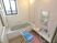 サムネイル 施設の写真 腰を掛けられる段差がある広い浴槽。洗い場には背もたれとひじ掛けのついたシャワーチェアが置かれている。
