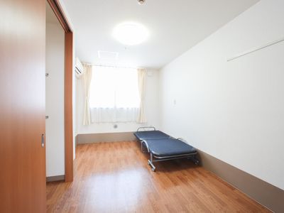 明るい居室のベッドと窓