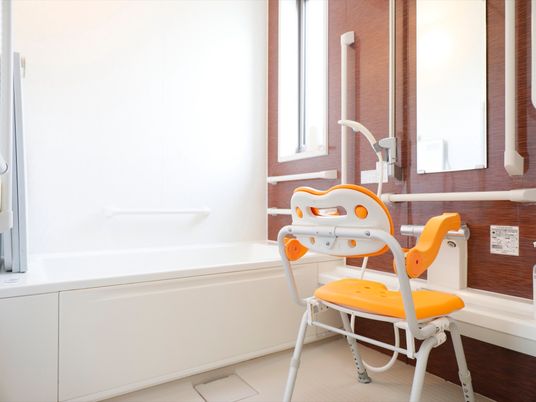 デザイン性のある個室の浴室。洗い場の床は滑りにくい仕様になっており、壁には複数の手すりが設置されている。