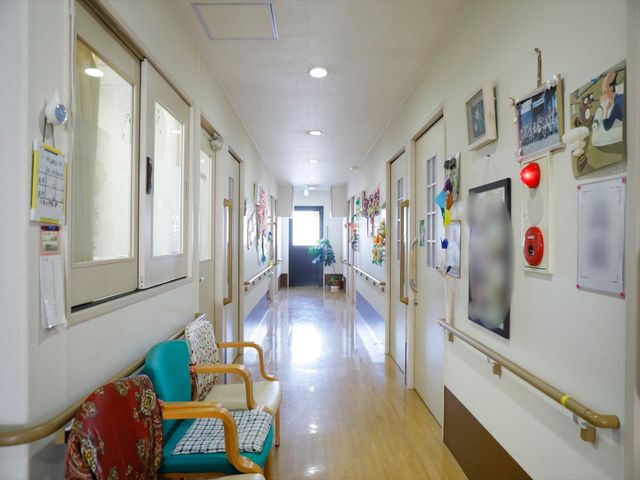 明るく清潔な廊下 通路 手すり完備で安全が考慮された廊下です。照明が心地よい明るさを提供し、壁に飾られた絵がアクセントになっています。