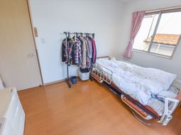 明るい居室のベッドと衣類