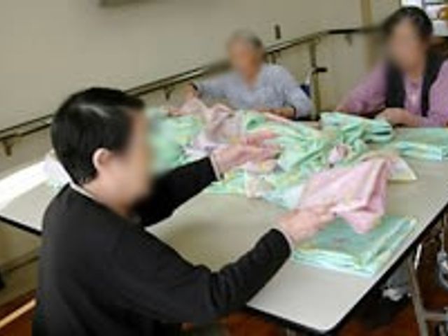 テーブルで作業中の様子 多目的室 広めのテーブルで複数の方が協力しながら作業を行っています。働く場として和やかな環境です。