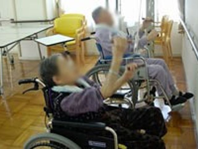 高齢者が運動する空間 機能訓練室 高齢者の方が自然光が差し込む明るい空間でリハビリに取り組んでいます。身体を動かす環境が整っています。