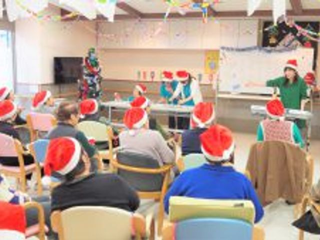 クリスマスイベントの居室 居室 楽しげなクリスマスイベントが開催されています。色とりどりの帽子をかぶった人々が集まり、和やかな雰囲気で過ごしています。