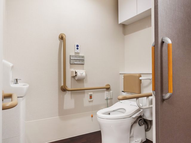 バリアフリートイレ設備 トイレ 安全で快適な手すり付きのトイレスペースです。移動や立ち座りが楽に行えるよう、工夫が凝らされています。
