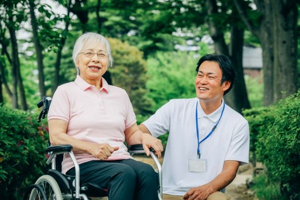 車椅子の利用者と笑顔のスタッフ