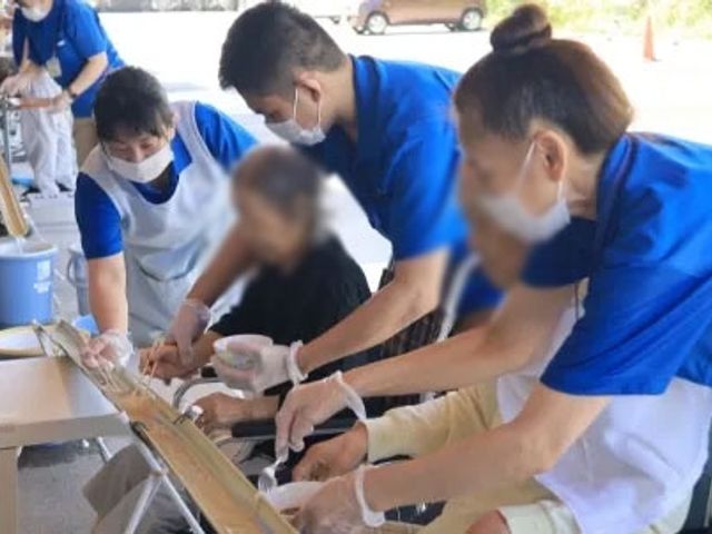 竹の流しそうめん体験の様子 スタッフイメージ 楽しくスタッフと一緒に流しそうめんを体験しています。和気あいあいとした雰囲気です。