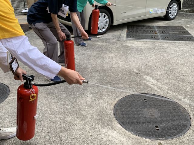 消火訓練の様子 エントランス 職員が参加する消火訓練です。消防設備の使用方法を実践でしっかりと学べます。