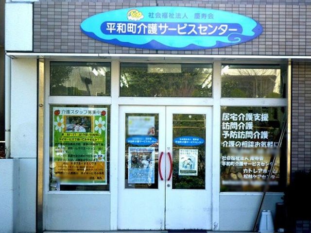 青い看板が目立つ施設入口 看板 青色の看板とガラスドアが目に留まるエントランスです。明るい雰囲気が感じられます。