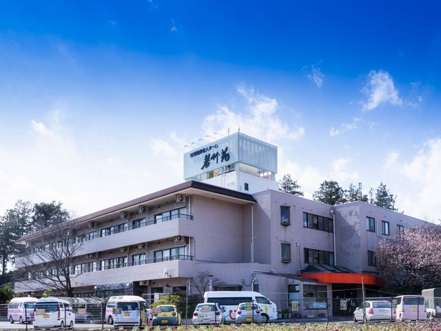建物の外観 外観 広々とした駐車スペースが整った建物です。青空の下、訪れる人々を迎え入れる雰囲気があります。