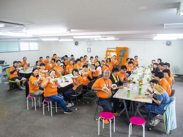 スタッフの団らん風景 休憩室 明るい休憩室でスタッフが集まり、一緒に食事を楽しんでいる様子です。リラックスした空間です。