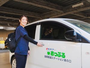 車のそばで笑顔のスタッフ  