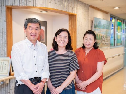 笑顔の3人が並ぶ廊下  