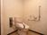 サムネイル 施設の写真 壁にL字型の手すりを設置しており、トイレに座りやすくなっている。壁にはお尻洗浄のスイッチが用意されている。