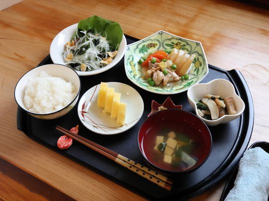 施設の写真 黒いお盆の上に食事が並べられている。お箸は箸置きに置かれている。食事に合うような模様のお皿が選ばれている。