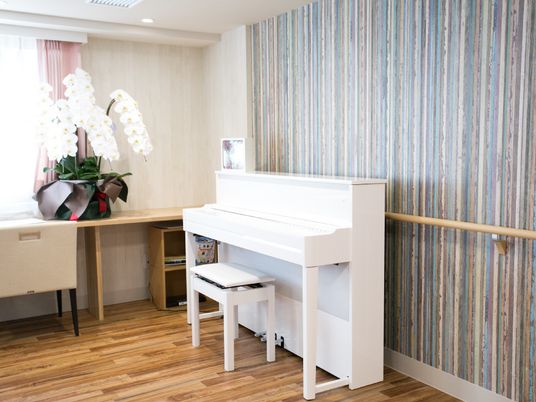 施設の写真 共有スペースには真っ白なピアノが置かれ、イベントごとに利用される