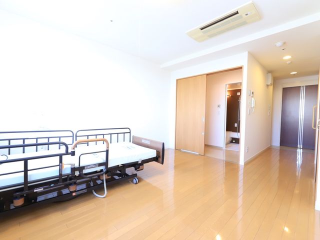 快適な個室療養環境 居室 清潔感のあふれる居室は、ゆったりとしたスペースで日々の暮らしに安らぎを提供します。ベッドの周囲にも余裕があり、動線も考慮されています。