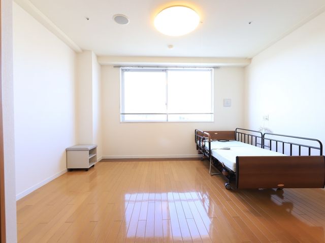 清潔な居室の一角 居室 窓から降り注ぐ光が明るく、居心地の良い部屋です。日々の生活を快適に送るための配慮が行き届いています。