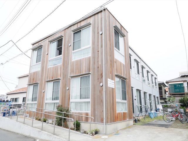 木目調の外壁の建物 外観 木目調を基調とした落ち着いた雰囲気の外観です。バリアフリー設計のエントランスで、誰もが快適に出入りできます。