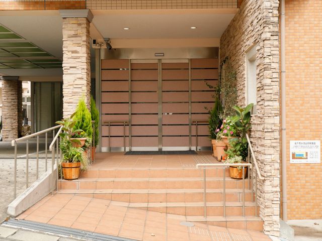 玄関アプローチのエントランス 玄関 手すり付きのアプローチは、バリアフリー設計を意識しており、安全に出入りいただけます。花々に囲まれたエントランスで、訪れる方を温かくお迎えします。