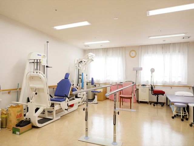 機能訓練器具とベッドの部屋 機能訓練室 充実した訓練機器が整う明るい部屋です。回復期リハビリテーションに対応しております。