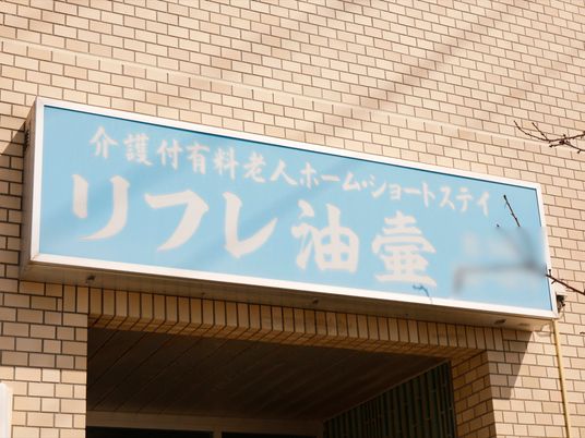 青い看板の明るい施設入口