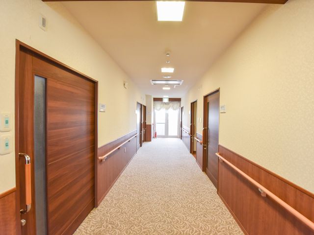 明るい廊下と部屋の扉 廊下 手すりが整った清潔感のあふれる廊下です。静かな環境でのお仕事をお求めの方にも安心いただける空間です。