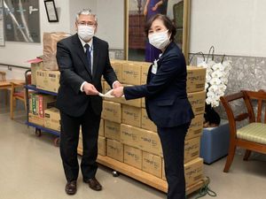 マスク姿の職員2人の引き渡し場面  