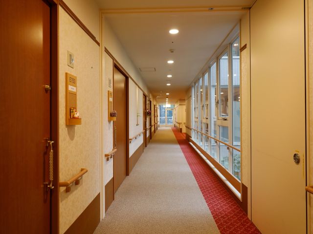 長い廊下と部屋のドア 通路 明るく広々とした廊下が、訪れる人を温かく迎えています。