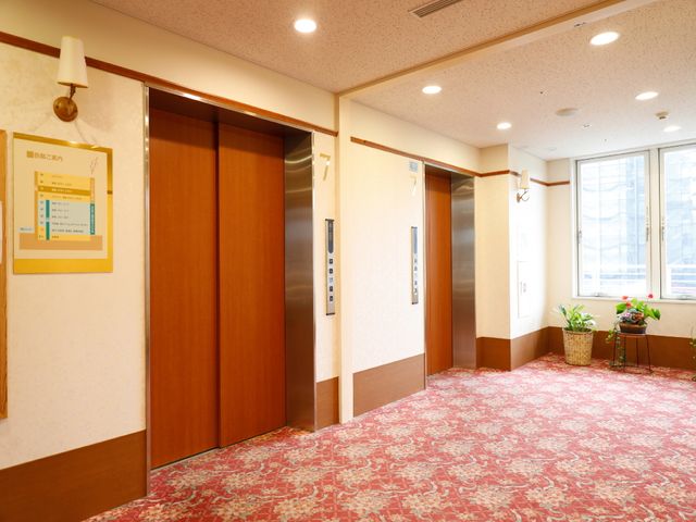 清潔な廊下とエレベーター エレベーター前 エレベーター前には掲示物があり、明るく清潔感のある空間です。