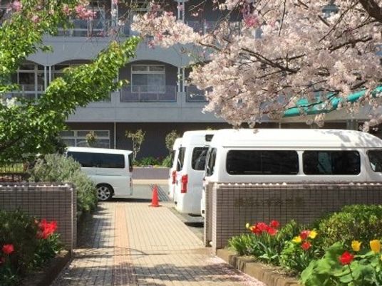 桜と送迎車の外観  